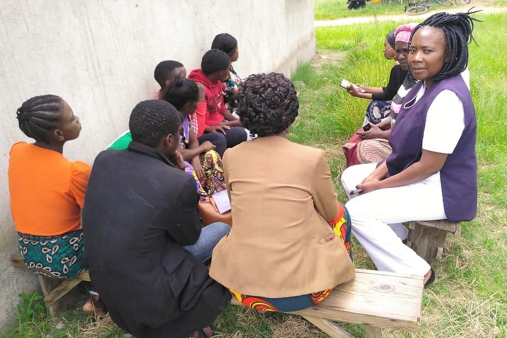 Nurse Carole during a community outreach Nurse Carole sitting among a group of people during a community outreach, Zambia